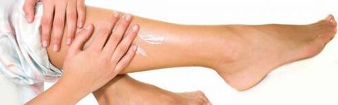 Applying a healing cream to the legs with varicose veins